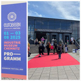 Ein Schild wirbt für das EuroBean Chocolate Festival im Industriemuseum Chemnitz vom 1. bis 3. August 2025. Daneben schreiten die Menschen an einem sonnigen Tag über einen roten Teppich in das Gebäude des Industriemuseums Chemnitz.